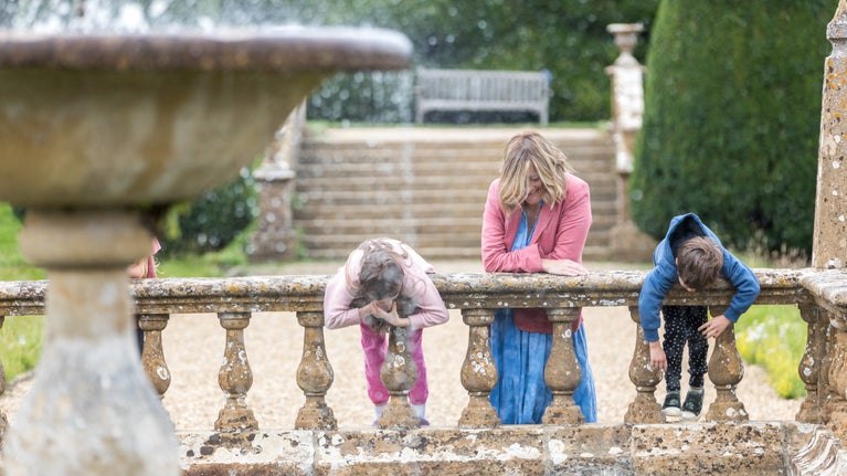 Visitors looking into the fountain pond at Montacute House, Somerset